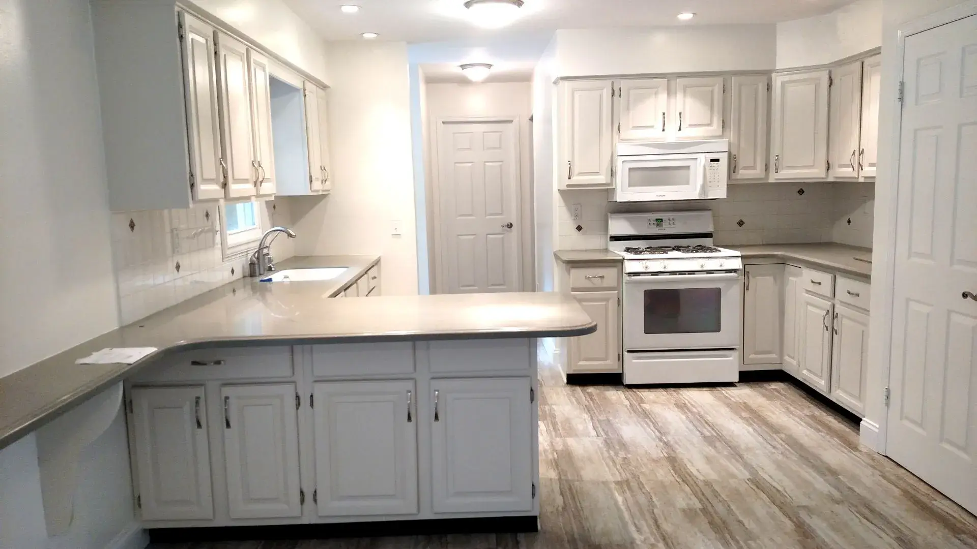 Modern kitchen painting and renovation in Ottawa - white cabinets, marble island, professional finishing